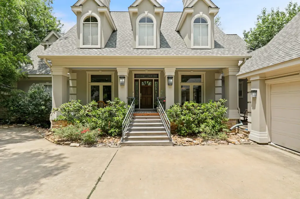 A stucco custom home with three arched dormers, designed and built by Envision Design Build