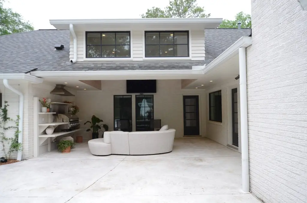 A remodeled back porch with black steel windows and an outdoor kitchen, built by Envision Design Build