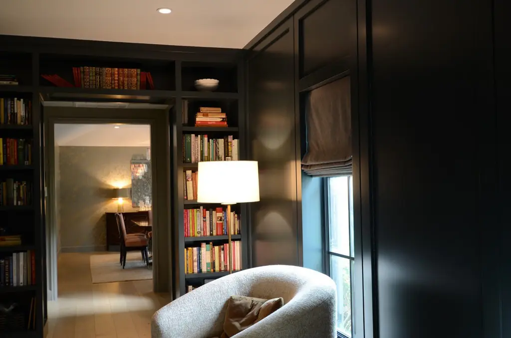 A dark panelled music room with floor to ceiling shelving, a remodel by Envision Design Build
